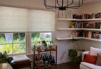 Custom sheer roller shades covering large window in stylish San Mateo living room